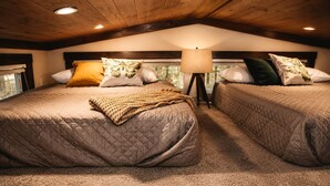 A cozy bedroom with two beds, a lamp, and a window. - Incredible Secluded Cabin wit Barbecue and Privileged Sights in Tracy City, Tennessee (Tracy City)