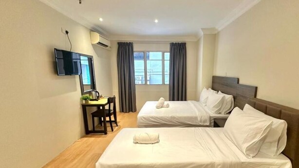 A hotel room with two beds, a desk, a chair, a flat-screen TV, and a window with curtains. - Swing & Pillows at Bukit Bintang City (Kuala Lumpur)