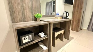 A wooden vanity with a mirror, a small plant, a safe, and a towel. - Swing & Pillows at Bukit Bintang City (Kuala Lumpur)