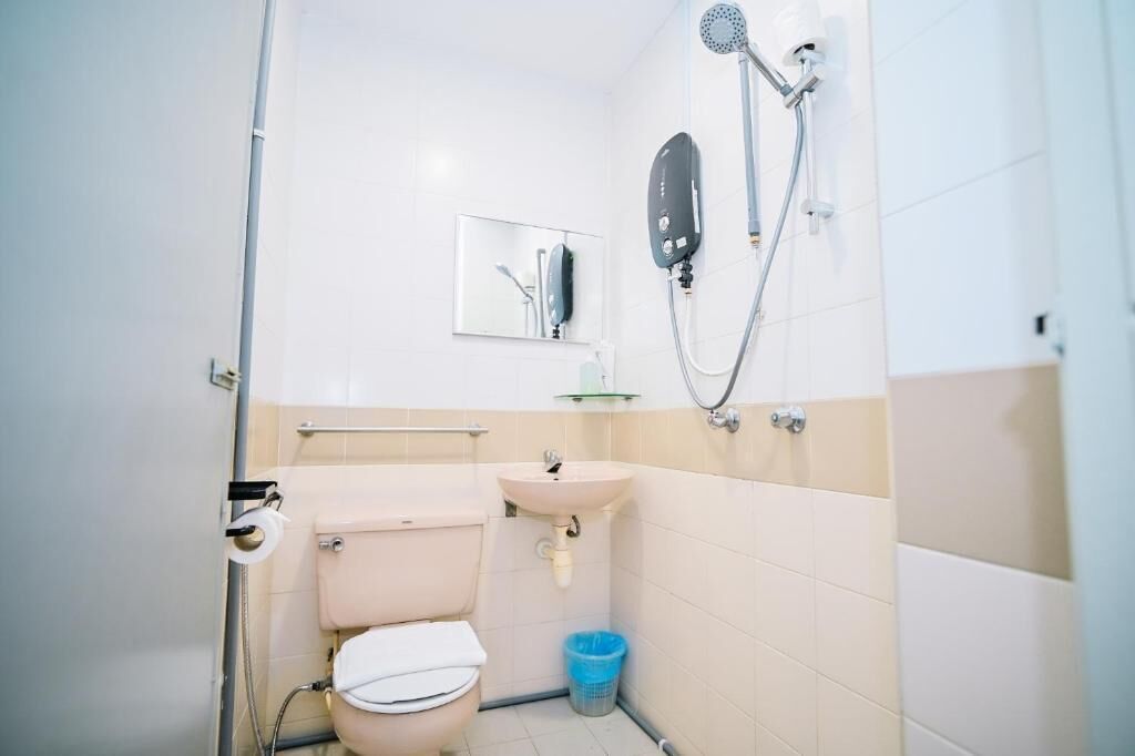 Une petite salle de bain avec des toilettes, un lavabo et une douche.