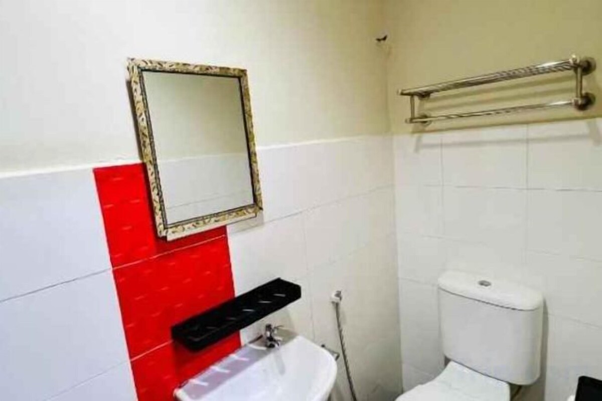 A bathroom with a white sink, a mirror, and a toilet.