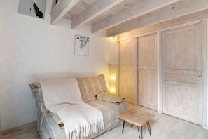 Una habitación acogedora con sofá, una mesita y armarios de madera.