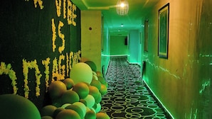 A hallway with green lighting, a patterned floor, and balloons along the wall. - Lé Nest Accommodation (Abuja)