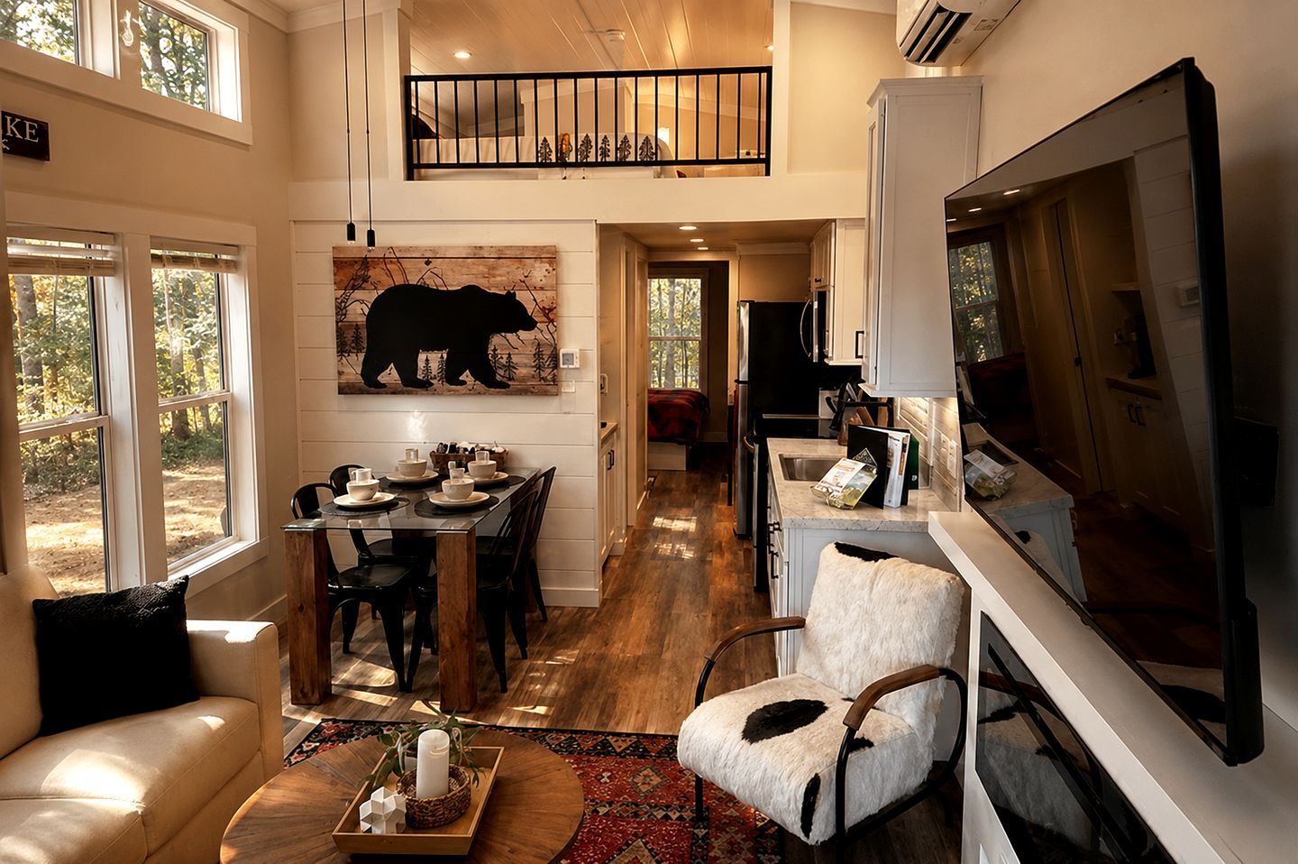 A spacious living area with a dining table set for four, a fireplace, and a large painting of a bear on the wall.