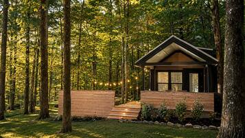 A cabin with a wooden exterior, surrounded by a forest.