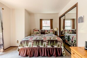 Quarto com cama grande, espelho e cômoda.