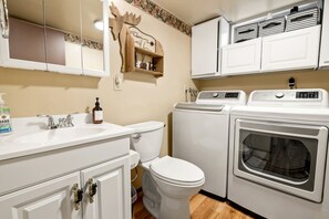 Ein kleines Badezimmer mit Toilette, Waschbecken und Waschmaschine.