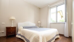 A bedroom with a bed, two bedside tables, a window, and a nightstand. - Room 'Stanza in Villa Magica' with Wi-Fi and Air Conditioning (Credaro)