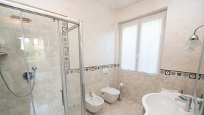 A bathroom with a glass shower enclosure, a bidet, a toilet, and a sink. - Room 'Stanza in Villa Magica' with Wi-Fi and Air Conditioning (Credaro)
