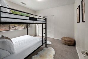 A bunk bed room with a window, a door, and a round ottoman. - Intimate Wonderful Rental with Jacuzzi in Arizona (Sedona)
