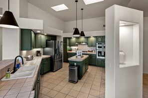 A modern kitchen with green cabinets, stainless steel appliances, and pendant lighting. - Intimate Wonderful Rental with Jacuzzi in Arizona (Sedona)