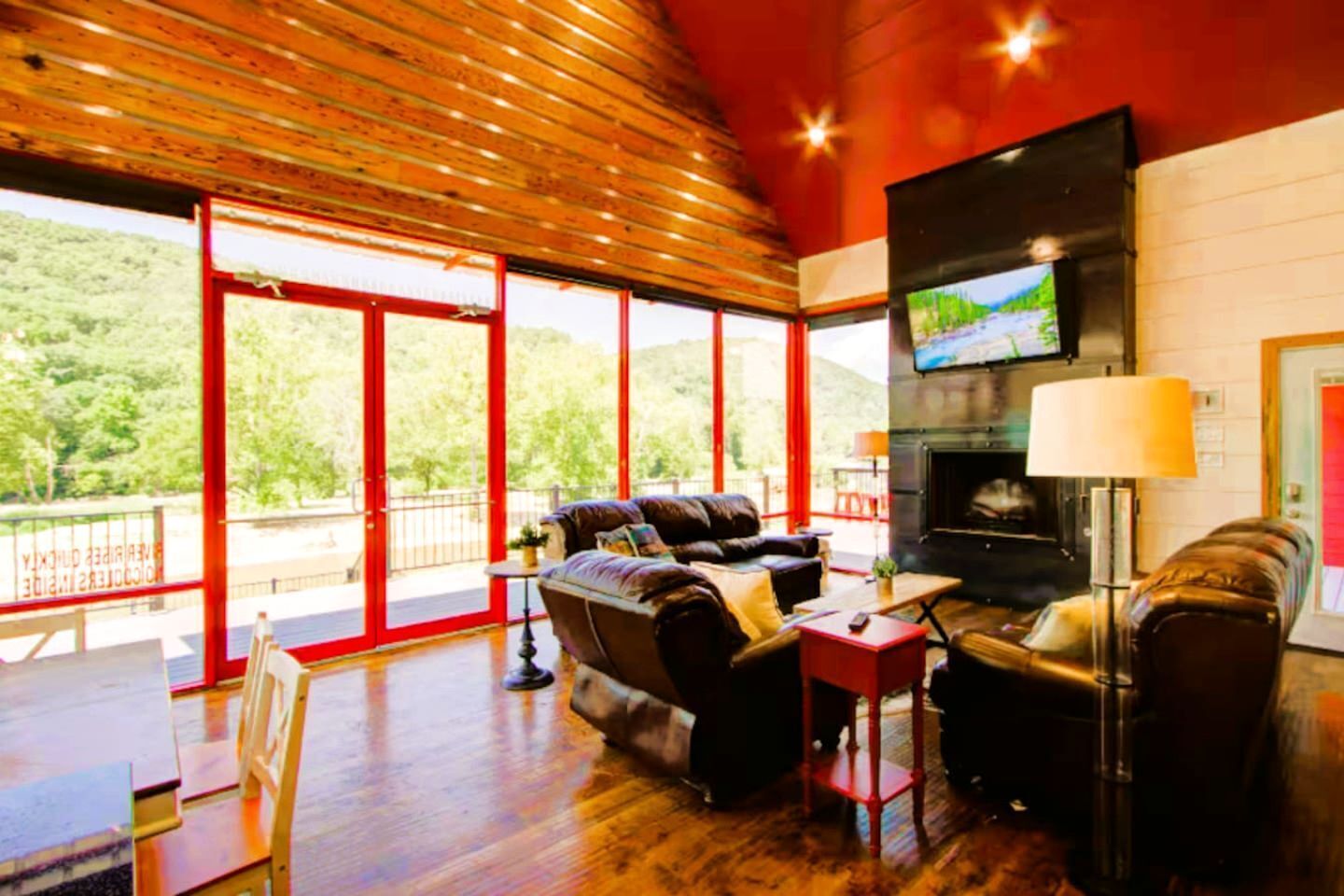 A spacious living area with a fireplace, comfortable seating, and large windows offering a view of the outdoors.