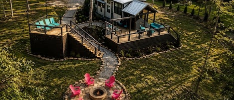 A modern house with a deck, a fire pit, and outdoor seating.