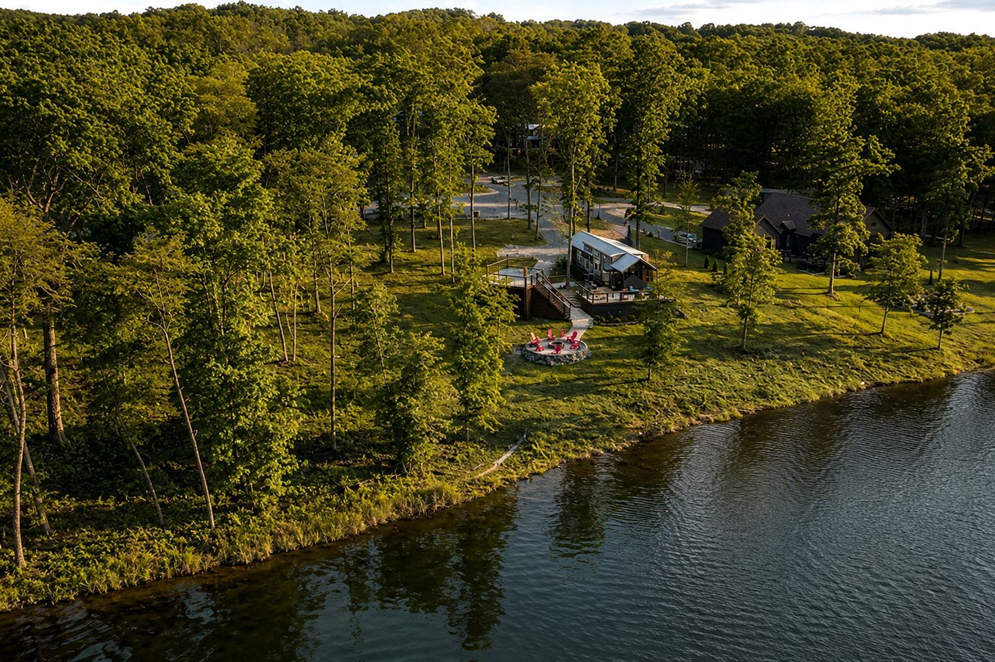 A lakeside property with a cabin, a dock, and a small docked boat.