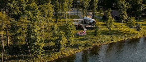 A lakeside property with a cabin, a dock, and a small docked boat.