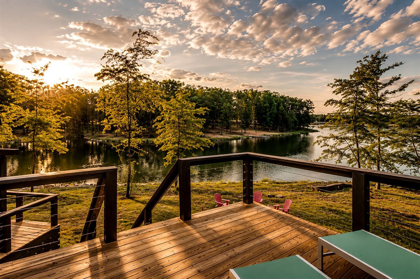 A wooden deck with a view of a lake and trees.