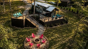 A modern house with a deck, a fire pit, and outdoor seating.