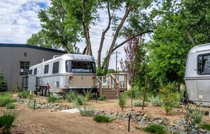 Una autocaravana estacionada en un camping, con un edificio al fondo.