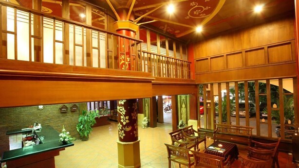 A spacious lobby with a high ceiling, wooden columns, and a balcony overlooking the street. - Liberety Patong Resort (Patong)