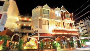A multi-story hotel with a traditional architectural style, featuring balconies and a well-lit entrance. - Liberety Patong Resort (Patong)