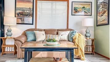 A living room with a brown leather sofa, a coffee table, and two side tables with lamps.