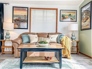 A living room with a brown leather sofa, a coffee table, and two side tables with lamps.