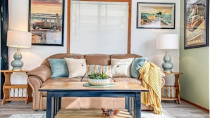 A living room with a brown leather sofa, a coffee table, and two side tables with lamps.