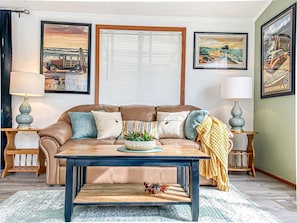 A living room with a brown leather sofa, a coffee table, and two side tables with lamps.