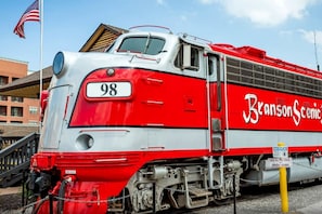 A red and white train with the number 98 and the name 'Branson Scenic' on its side.
