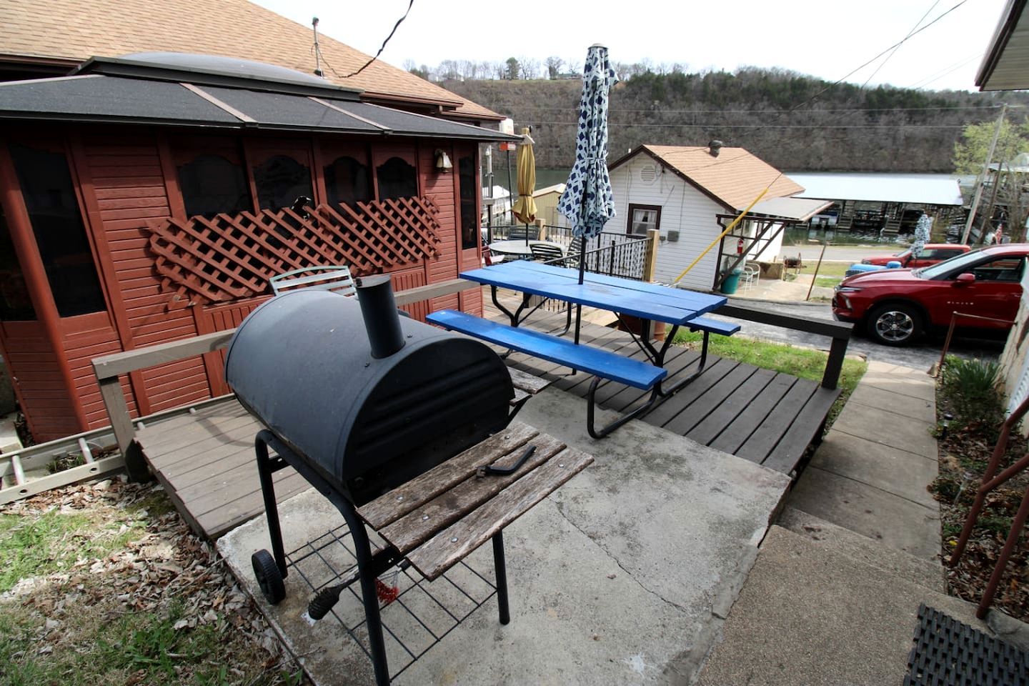 A barbecue grill, picnic table, and outdoor seating area with a wooden deck.