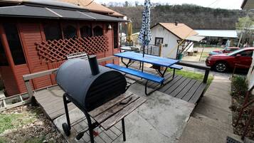 A barbecue grill, picnic table, and outdoor seating area with a wooden deck.