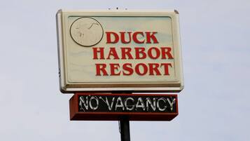 A sign for Duck Harbor Resort with a 'NO VACANCY' message.