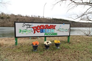 Un panneau indiquant « Salutations de Rockaway Beach, dans le Missouri » et orné d’une illustration de poisson.