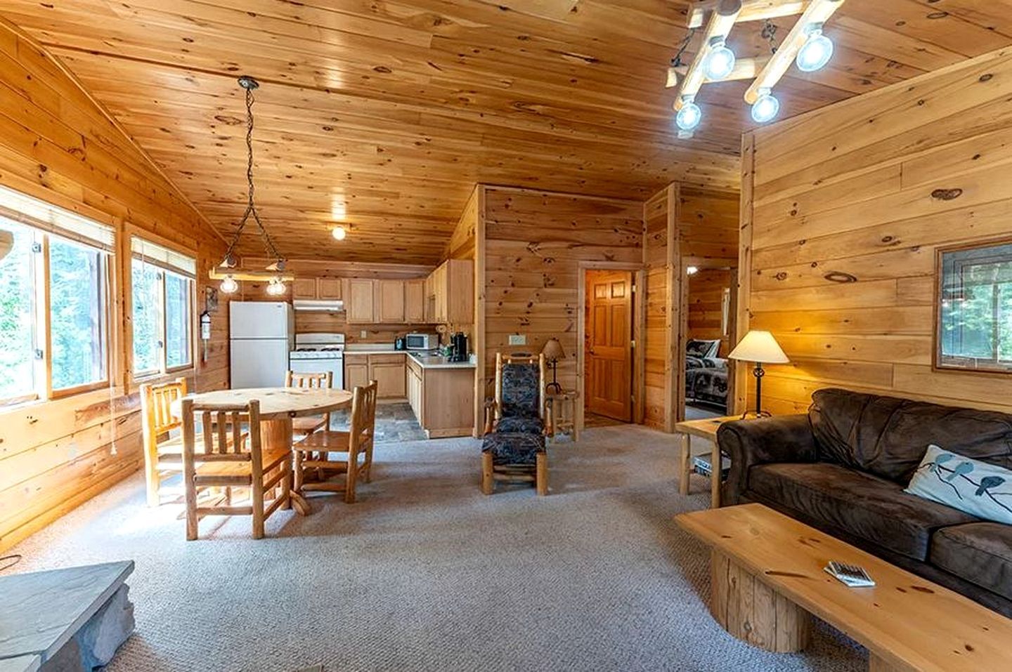 L’intérieur d’une cabane en rondins comprend un coin repas, une cuisine et un salon.