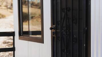 A white door with a black metal handle and a window with a brown frame.