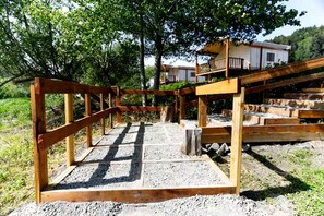 A wooden deck structure with a view of a house in the background.