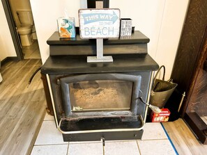 A wood-burning stove with a sign above it that reads 'THIS WAY TO THE BEACH.' - Modern Lake House near Hot Springs National Park in Arkansas, Complete with Private Dock and Woodburning Stove (Hot Springs)