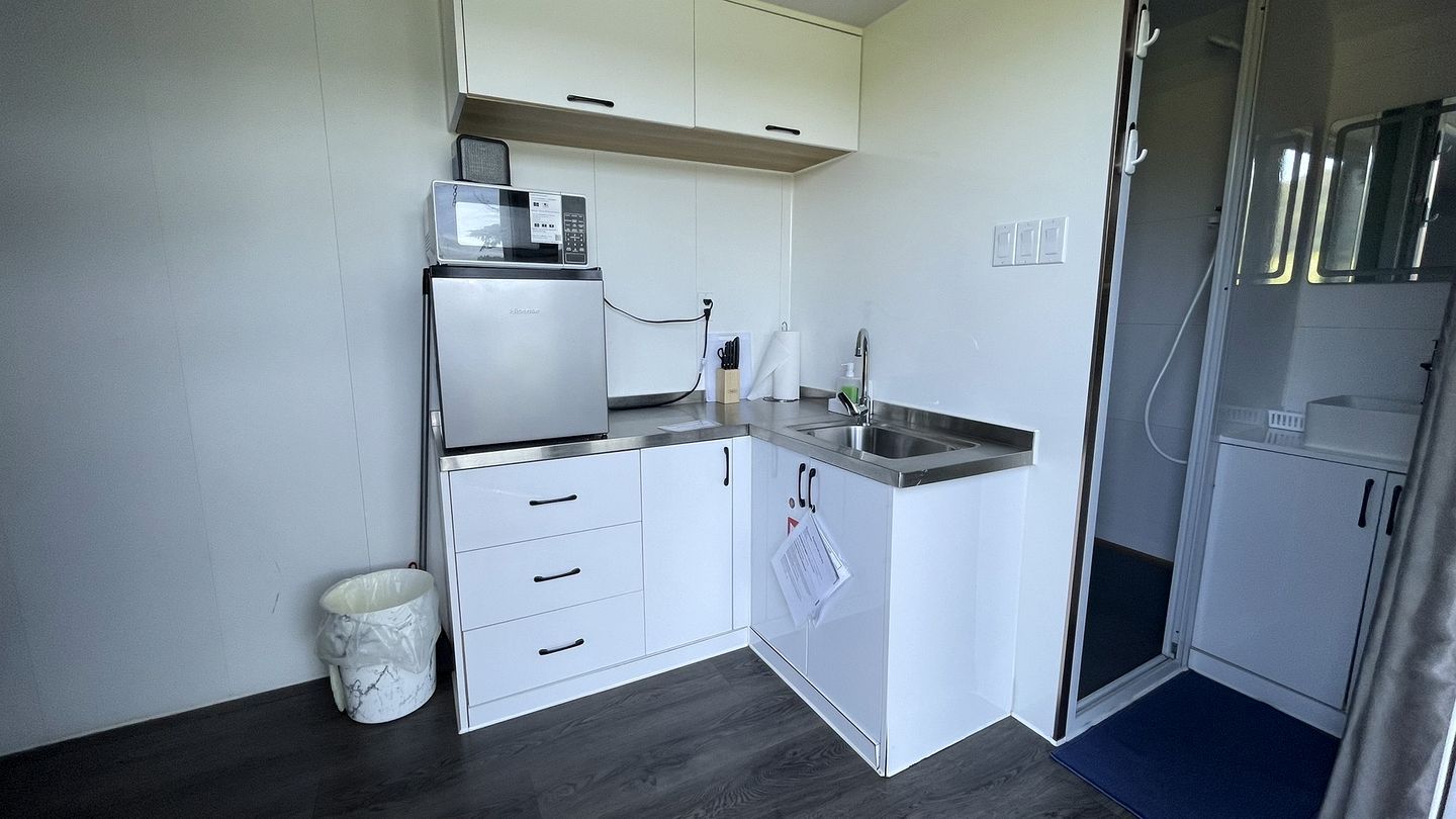 A compact kitchen with a built-in microwave, a sink, and a small countertop.