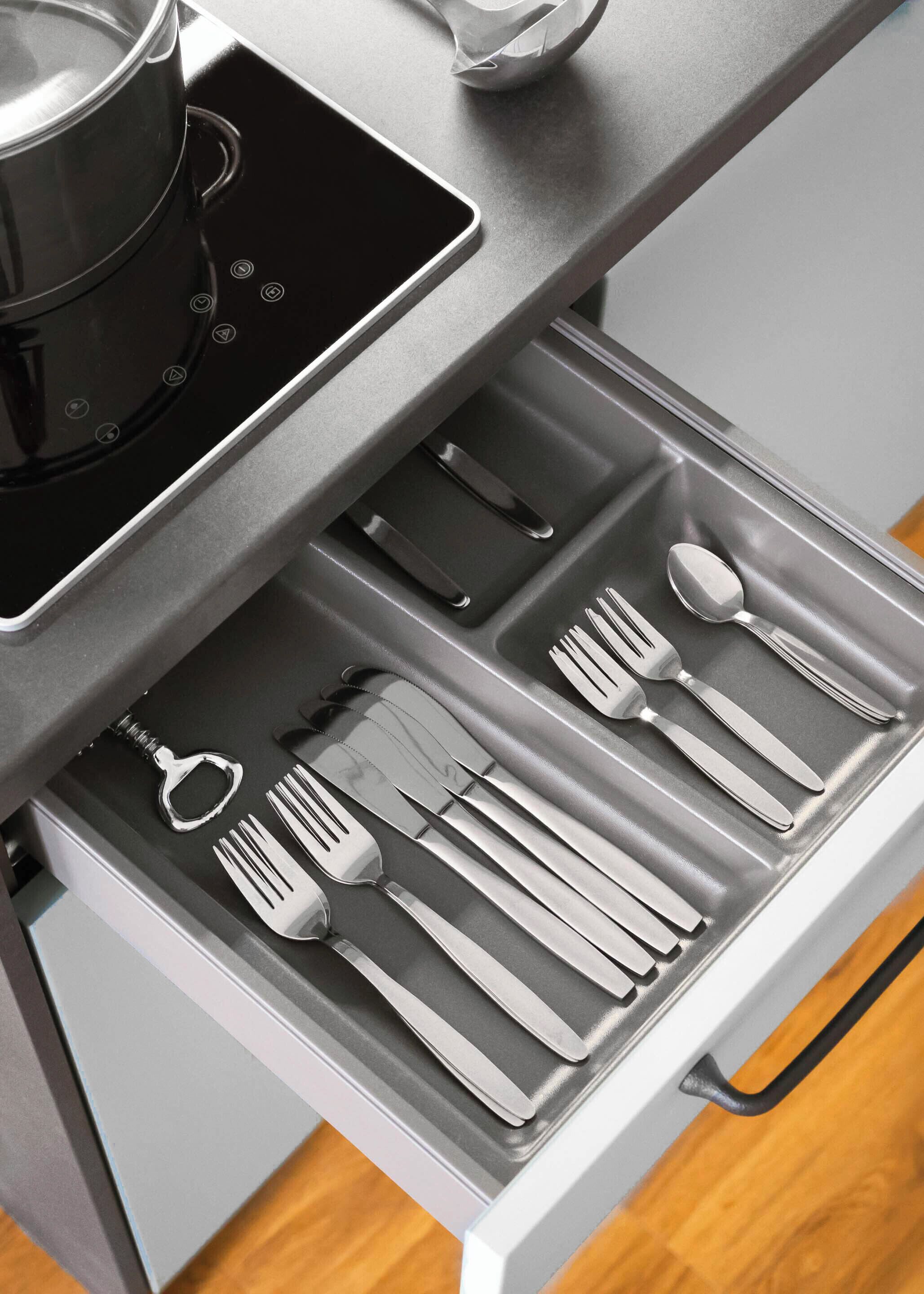Un cajón de cocina con utensilios organizados.