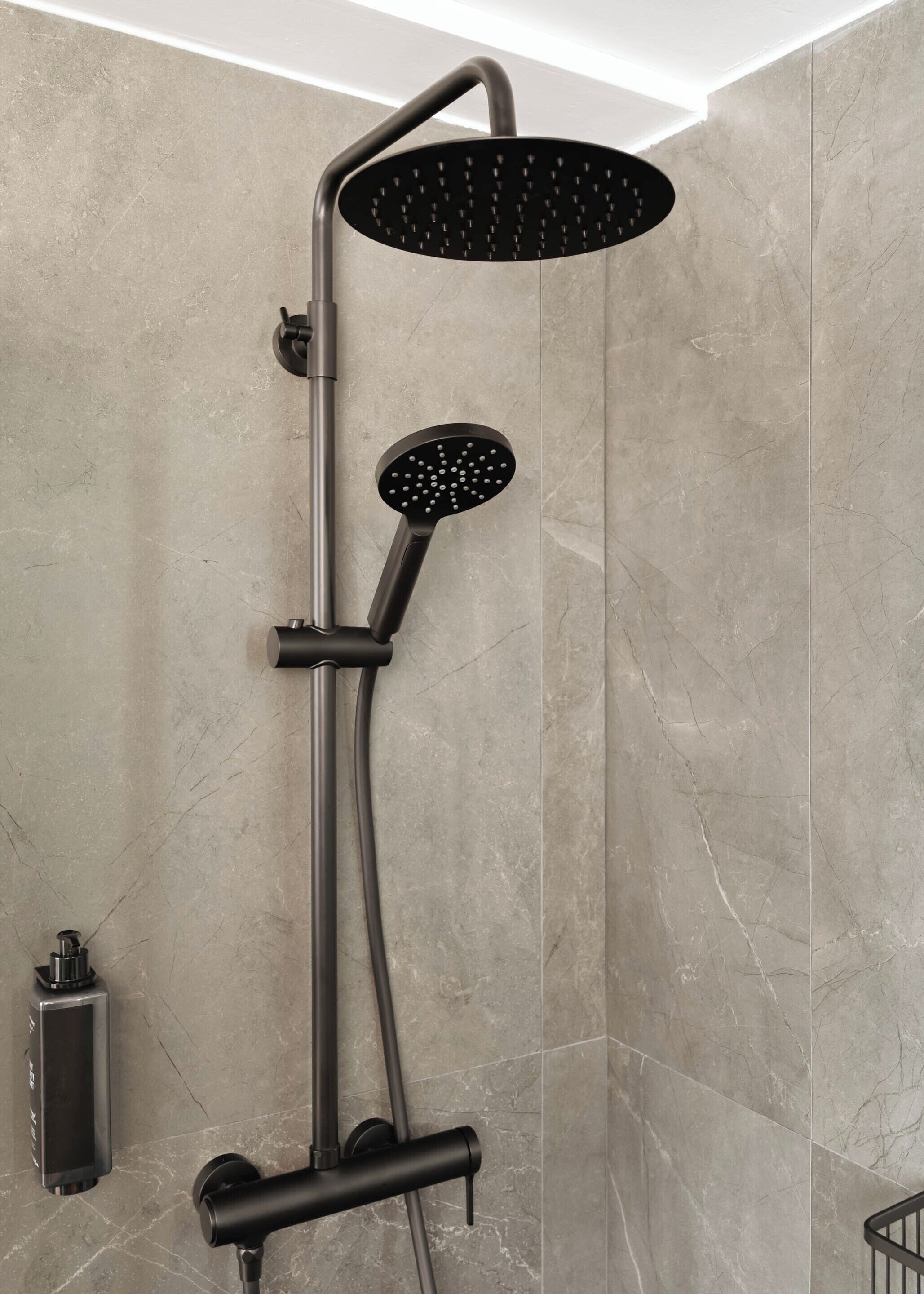 A modern shower with a curved head and a handheld showerhead.