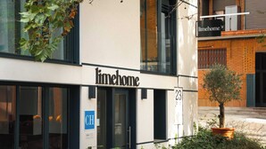 A modern building with a 'timehome' sign, a wheelchair accessibility symbol, and a small tree in a planter. - Limehome Madrid Calle de Bolivia (Madrid)