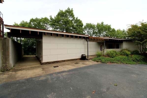 Ein Gebäude mit Garage, überdachtem Außenbereich und befestigter Auffahrt.
