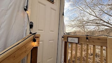 A wooden deck with a welcome mat, a door labeled 'Willow,' and a sign that reads 'Welcome.'