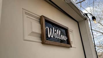 A white garage door with a 'Willow' sign and two light fixtures above it.