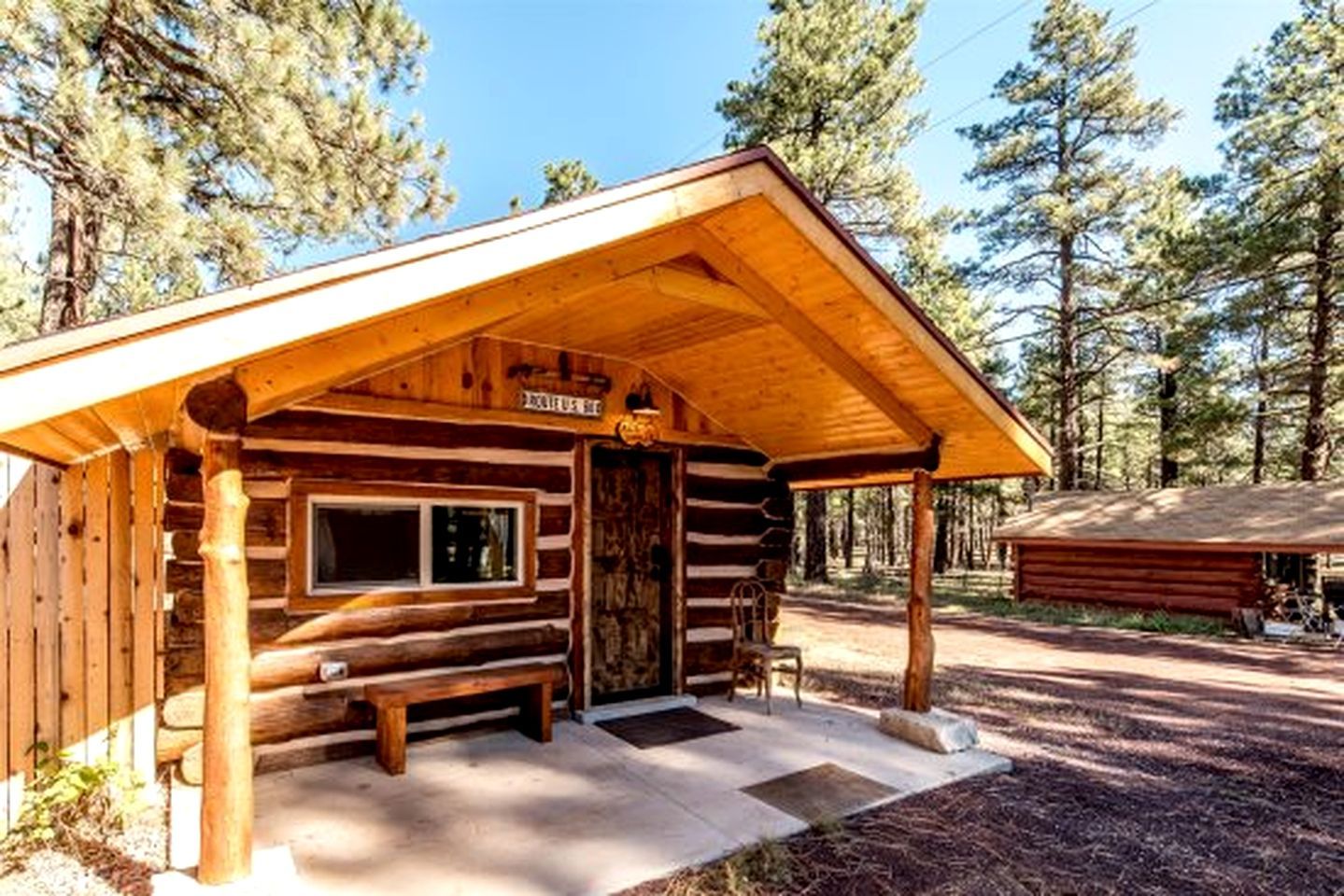 A log cabin with a porch, a window, and a door.