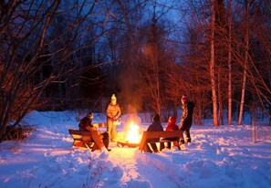 A group of people gathered around a campfire in a snowy forest. - Family-Friendly Cabin Surrounded by Nature with Indoor Sauna in Grand Marais, Minnesota (Grand Marais)