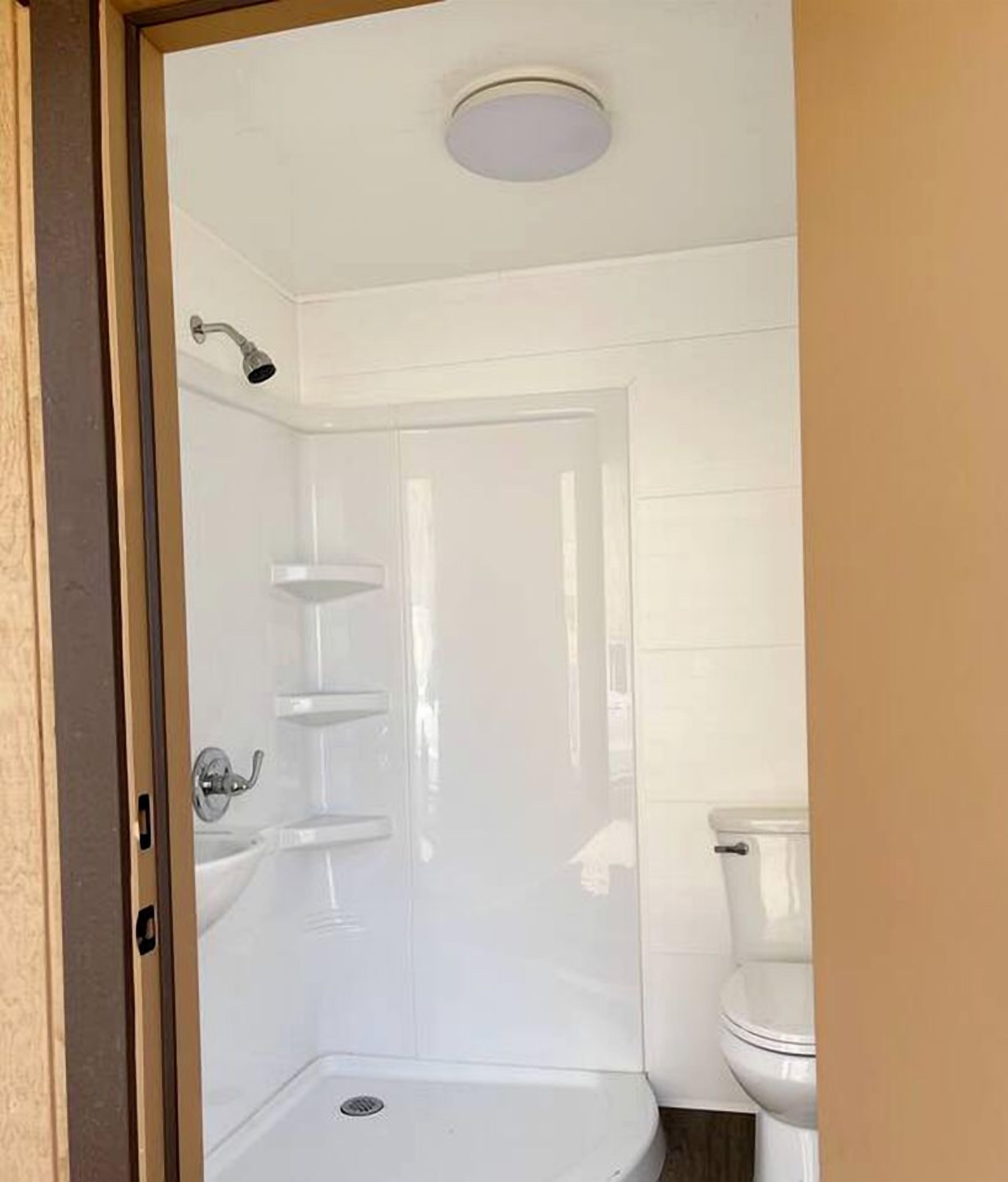 A bathroom with a shower, toilet, and a sink.