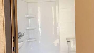 A bathroom with a shower, toilet, and a sink.