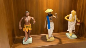 Three statues in a wooden display case. - Shree Shanteshwar Mahadev Inn (Varanasi)