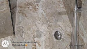 A modern bathroom with a marble floor, a glass shower enclosure, a white sink, and a towel rack. - Shree Shanteshwar Mahadev Inn (Varanasi)